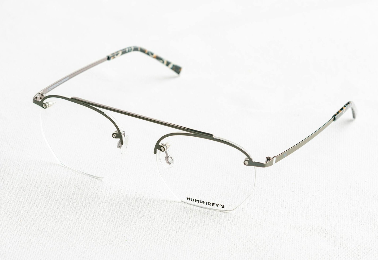 Close-up of stylish silver eyeglasses on a white background, highlighting design and details.