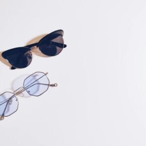 Flat lay of sunglasses and eyeglasses on a white background, perfect for fashion design concepts.